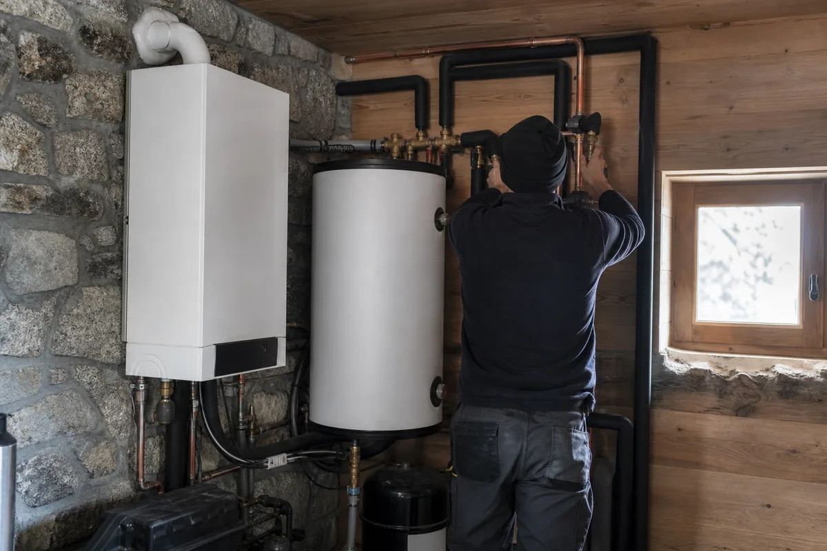 Chaudière et ballon d&rsquo;eau chaude dans un local technique de chalet savoyard